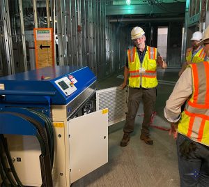 Laser professional talking in front of group with hard hats